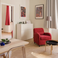 red armchair and coffee table in a clean, bright, well ventilated living room