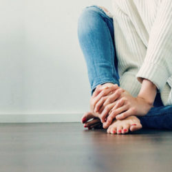 woman sitting on the floor barefooted and still feeling warm during winter