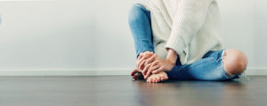 woman sitting on the floor barefooted and still feeling warm during winter